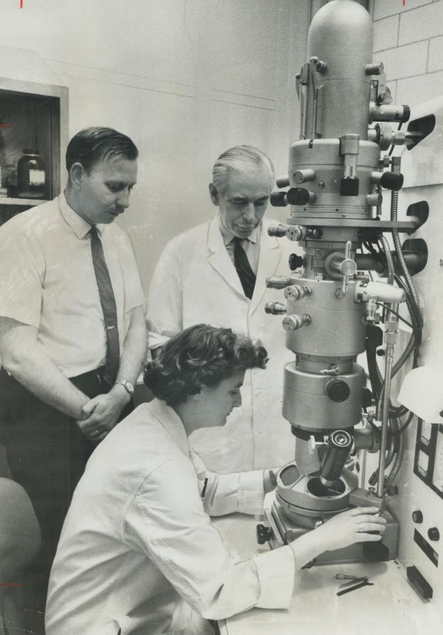 جون آلمیدا در کنار یک میکروسکوپ الکترونیکی