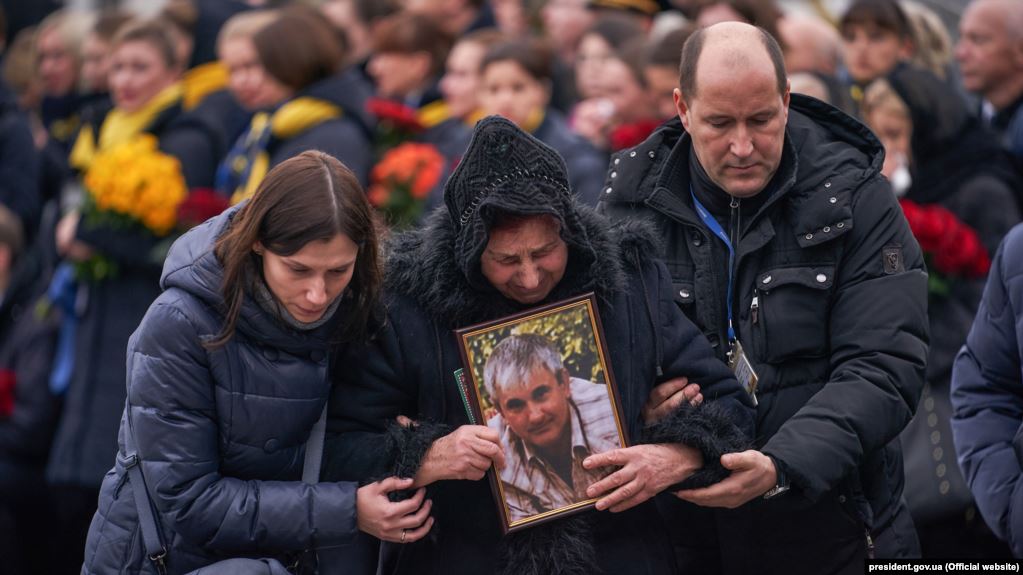 قاب‌عکس ولودیمیر گاپوننکا، خلبان هواپیمای اوکراینی، در دست مادرش در مراسم وداع با قربانیان پرواز ۷۵۲