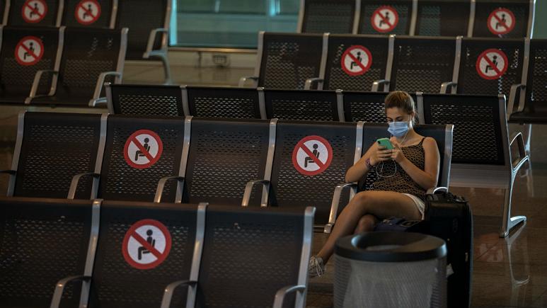 A passenger sits at Barcelona airport in Barcelona, Spain   -   کپی رایت  AP Photo